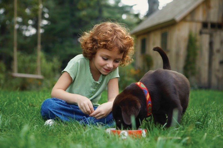 Girl with dog after repelling ticks naturally with NaturaLawn